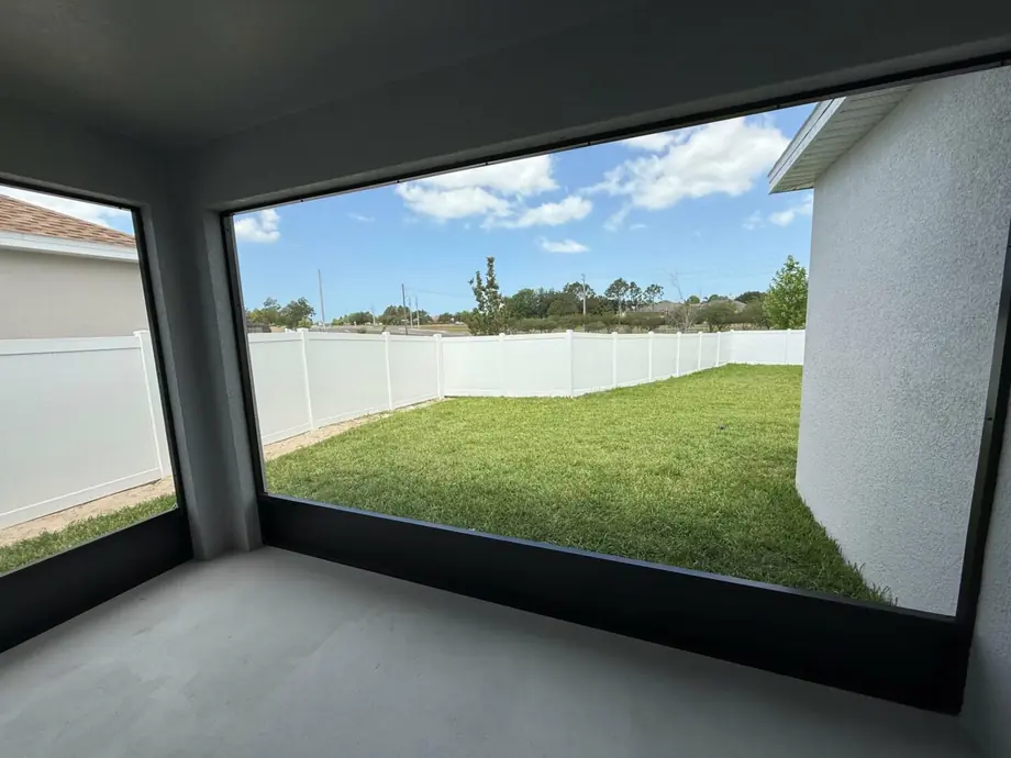 Enclosed back porch with screen panels between the existing columns