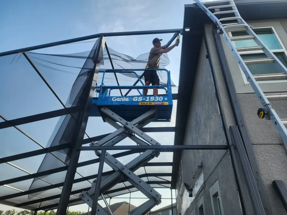 Crew fitting screen panels to a partly completed enclosure
