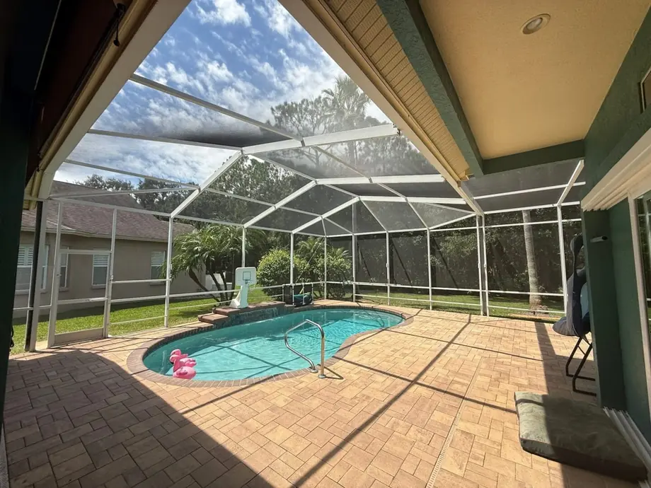 Screen room enclosure with aluminum framing and a solid roof panel